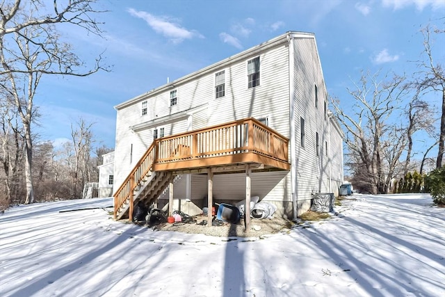 snow covered house featuring a deck