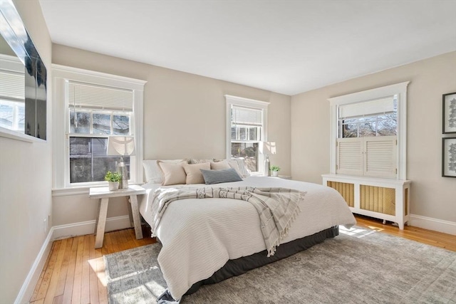 bedroom with radiator, wood-type flooring, and baseboards