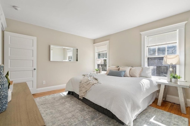 bedroom with light wood-style flooring and baseboards