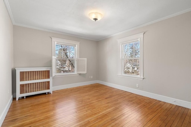 unfurnished room with light wood-style floors, plenty of natural light, and radiator heating unit