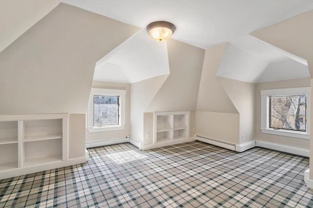 bonus room with a healthy amount of sunlight, built in shelves, baseboards, and lofted ceiling