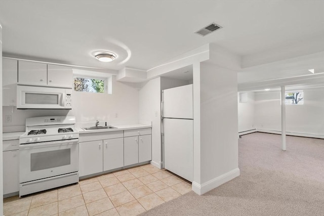 kitchen with white appliances, visible vents, light countertops, white cabinetry, and a sink