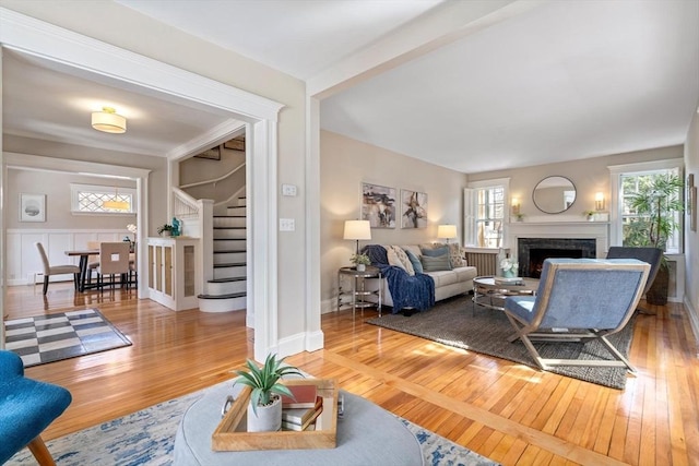 living area with stairs, hardwood / wood-style floors, and a fireplace