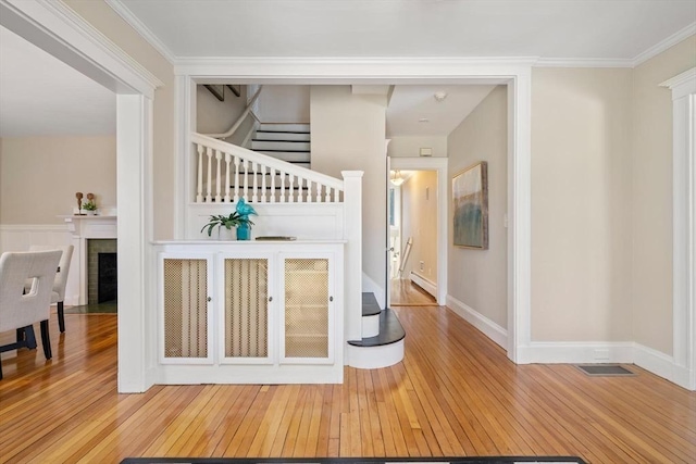 interior space featuring crown molding, stairway, and hardwood / wood-style flooring