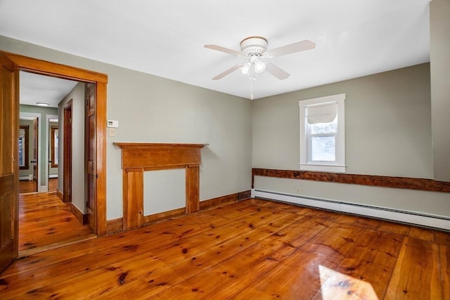 spare room featuring wood-type flooring, a baseboard heating unit, and ceiling fan