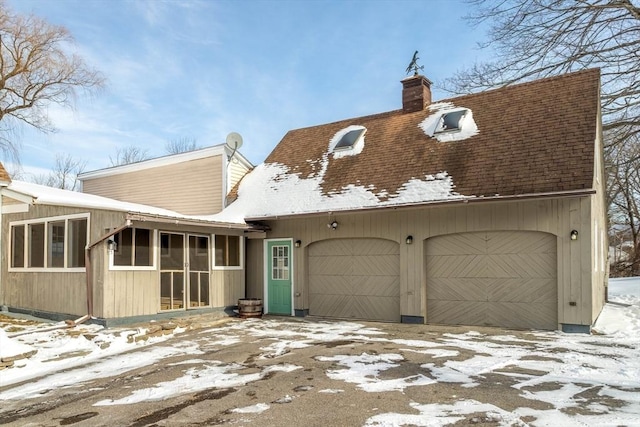 view of front facade with a garage and a sunroom