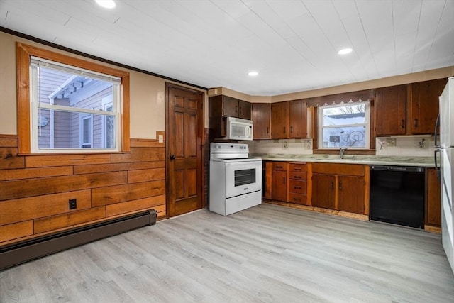 kitchen with sink, light wood-type flooring, baseboard heating, ornamental molding, and white appliances