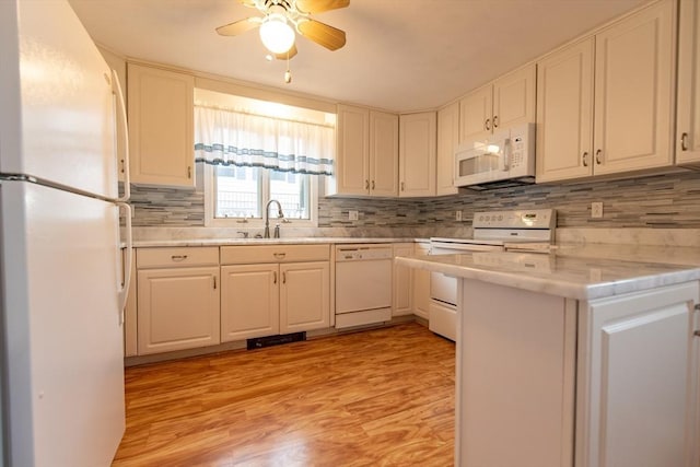 kitchen featuring white appliances, sink, light hardwood / wood-style flooring, ceiling fan, and white cabinetry