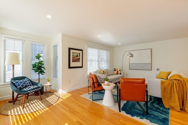 living room featuring baseboards, recessed lighting, plenty of natural light, and light wood-style floors