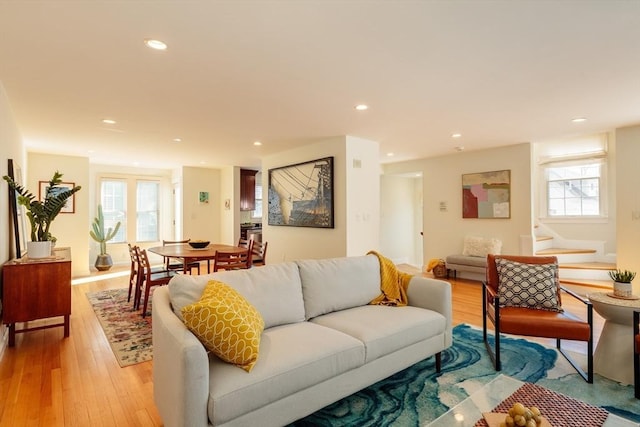 living area featuring a healthy amount of sunlight, light wood-style flooring, stairs, and recessed lighting