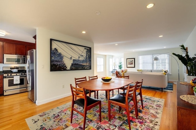 dining room with baseboards, light wood-style flooring, and recessed lighting