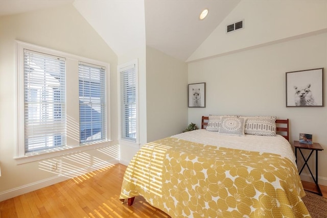 bedroom with recessed lighting, visible vents, wood finished floors, high vaulted ceiling, and baseboards