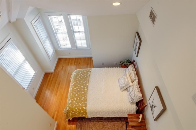 bedroom featuring baseboards, visible vents, wood finished floors, and recessed lighting