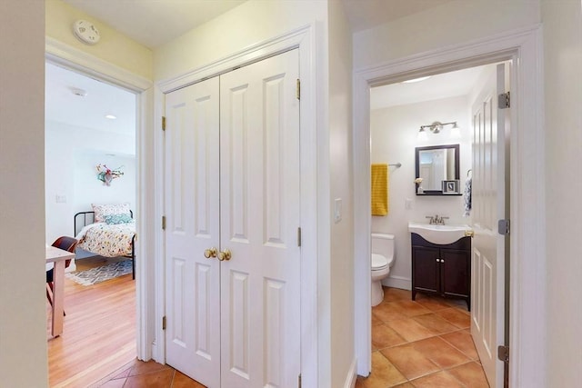 hall featuring light tile patterned flooring and a sink