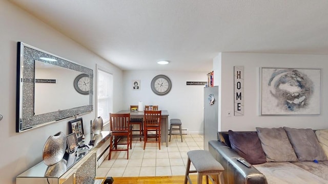 living area featuring baseboards and light tile patterned flooring