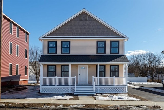 view of front facade with a porch and roof with shingles