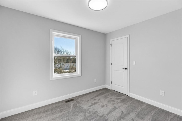 unfurnished room with baseboards, visible vents, and carpet flooring