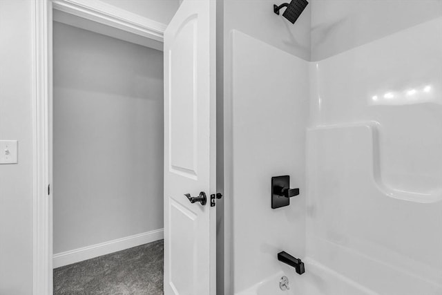 bathroom featuring bathing tub / shower combination and baseboards