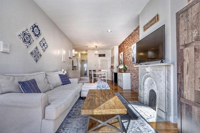 living room with brick wall and hardwood / wood-style floors