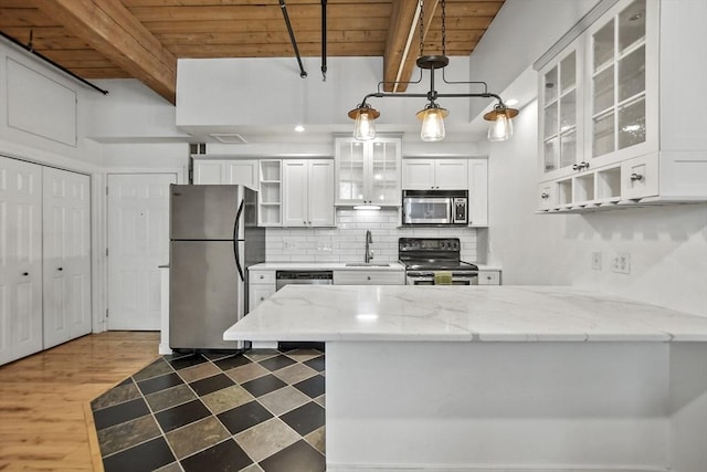 kitchen featuring white cabinets, wood ceiling, stainless steel appliances, pendant lighting, and beamed ceiling