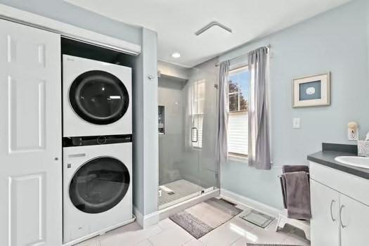 65 Tussock Brook Rd Unit 65, Duxbury, MA 02332 - full bathroom featuring estacked washer and dryer, a stall shower, vanity, baseboards, and tile patterned floors