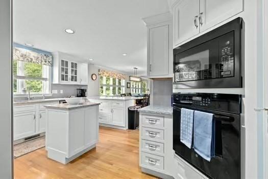 65 Tussock Brook Rd Unit 65, Duxbury, MA 02332 - kitchen featuring black appliances, white cabinets, light wood finished floors, a center island, and recessed lighting