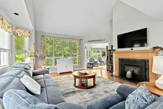 65 Tussock Brook Rd Unit 65, Duxbury, MA 02332 - living area featuring high vaulted ceiling, healthy amount of natural light, wood finished floors, and a fireplace