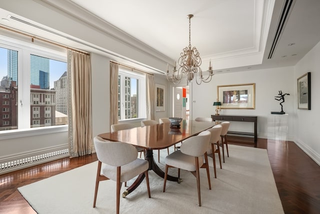 dining space with a raised ceiling, an inviting chandelier, ornamental molding, and wood-type flooring