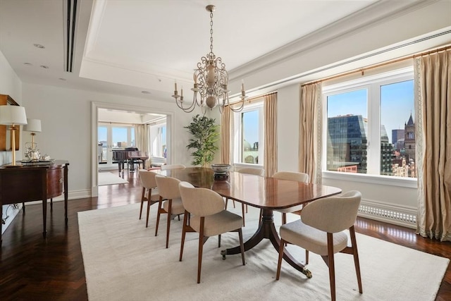 dining room with a raised ceiling, a notable chandelier, ornamental molding, parquet floors, and baseboards