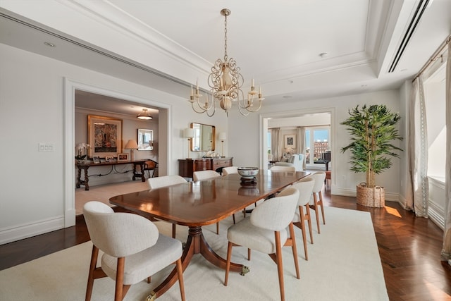 dining space with a tray ceiling, a chandelier, and dark parquet floors