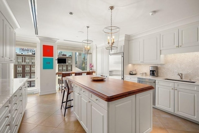 kitchen featuring a sink, a center island, white cabinetry, stainless steel appliances, and decorative backsplash