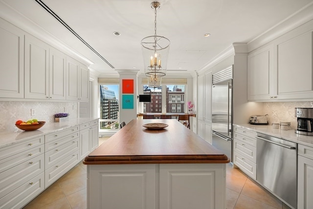 kitchen with stainless steel appliances, white cabinetry, tasteful backsplash, and a kitchen island