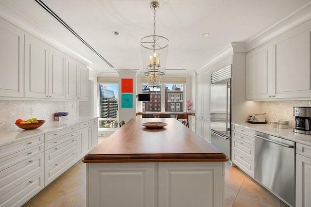 kitchen featuring light tile patterned flooring, appliances with stainless steel finishes, ornamental molding, and a center island