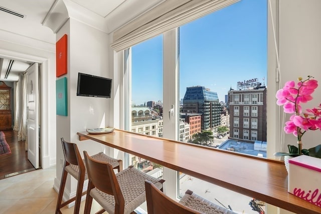 tiled dining space featuring crown molding