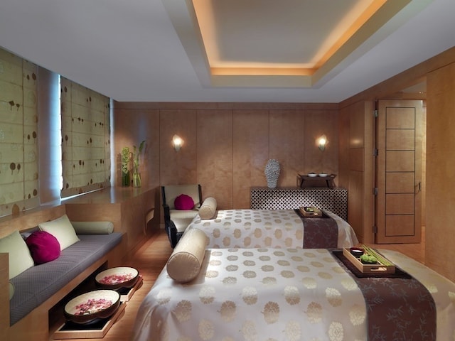 bedroom with wood walls and a raised ceiling