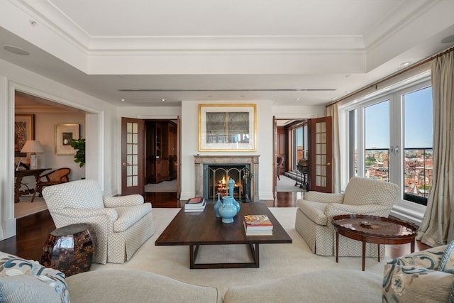 living room with a raised ceiling, french doors, crown molding, and hardwood / wood-style floors