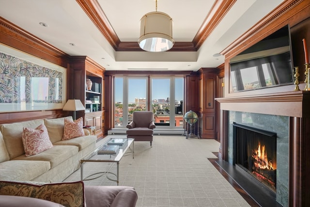 living room featuring a raised ceiling, crown molding, a premium fireplace, and light colored carpet