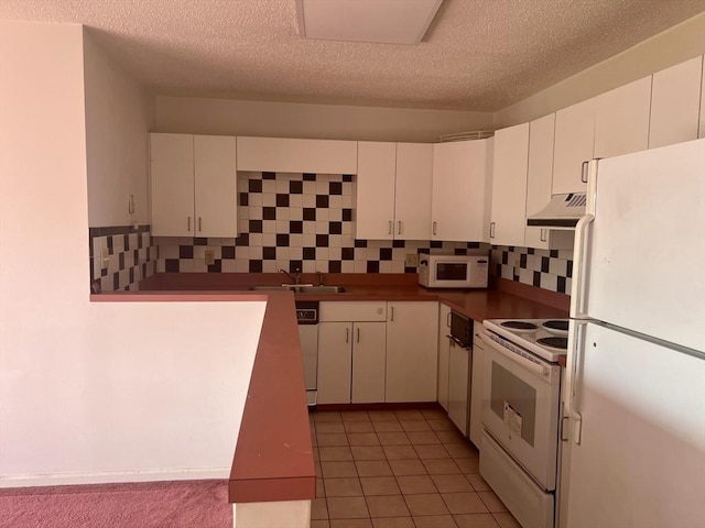 24 Corey St Unit 305, Everett, MA 02149 - kitchen featuring white appliances, a textured ceiling, tasteful backsplash, white cabinetry, and light tile patterned flooring