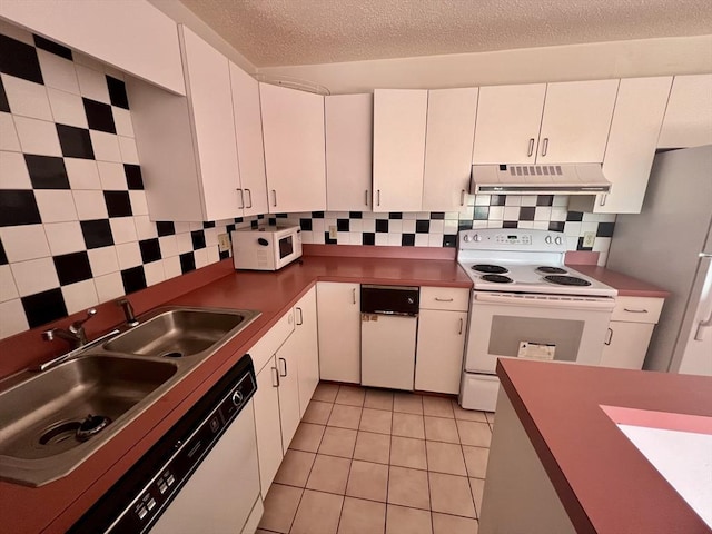 24 Corey St Unit 305, Everett, MA 02149 - kitchen featuring under cabinet range hood, white appliances, white cabinetry, a textured ceiling, and tasteful backsplash