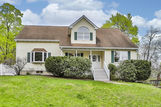 view of front facade with a shingled roof and a front yard