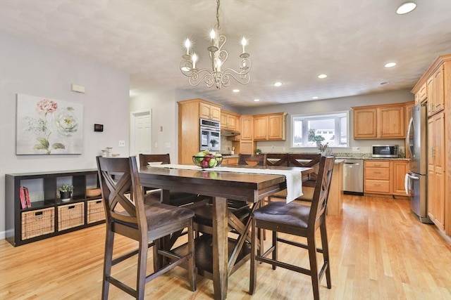 dining space featuring recessed lighting, an inviting chandelier, and light wood-style flooring