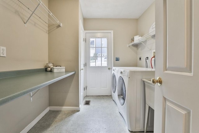 clothes washing area with baseboards, laundry area, independent washer and dryer, and visible vents