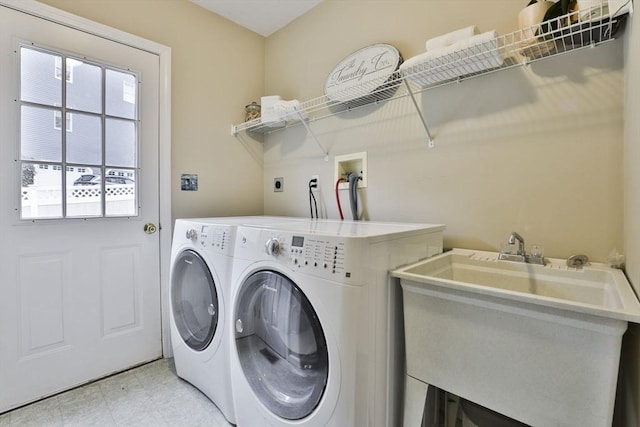 clothes washing area featuring a sink, laundry area, and washing machine and dryer
