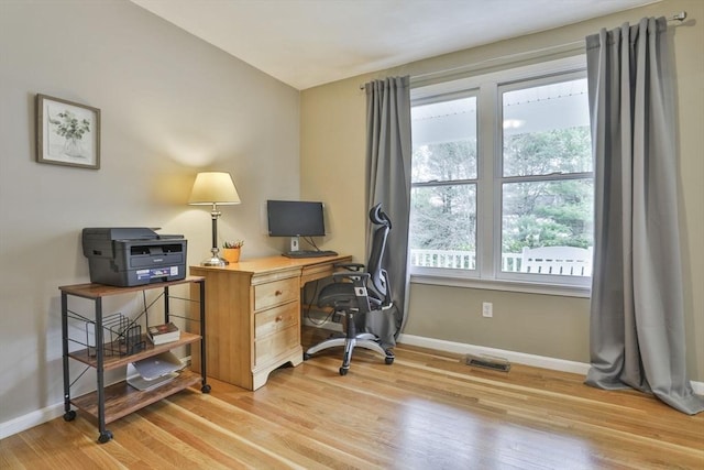 office space featuring baseboards, visible vents, and light wood finished floors