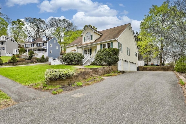 view of front of property with driveway, a residential view, a front yard, and a garage
