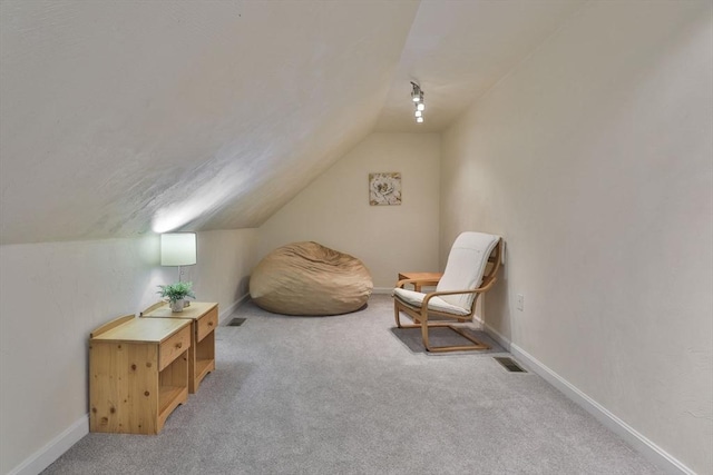 living area with carpet flooring, baseboards, visible vents, and lofted ceiling
