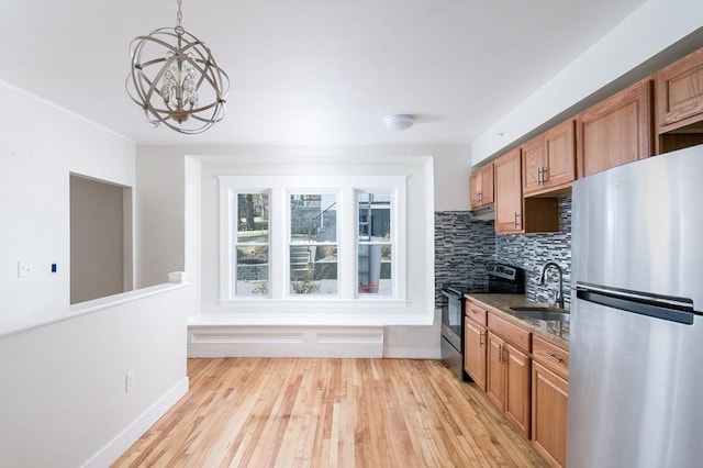 kitchen featuring sink, hanging light fixtures, decorative backsplash, a notable chandelier, and stainless steel appliances