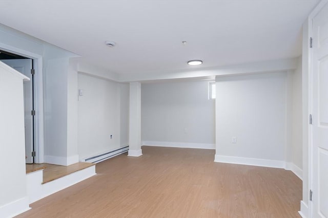 basement featuring a baseboard radiator and light wood-type flooring