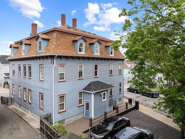 186 John St, Fall River, MA 02721 - back of property with a chimney, roof with shingles, and mansard roof