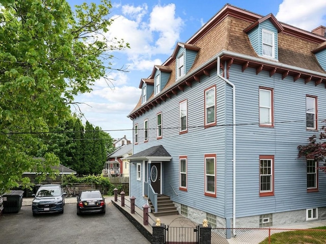 186 John St, Fall River, MA 02721 - view of front of property featuring roof with shingles, a fenced front yard, a gate, and mansard roof